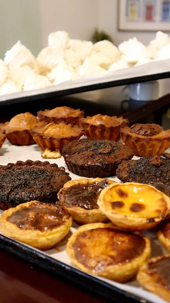 Tabuleiro de pastéis de nata e bolos acabados de sair do forno