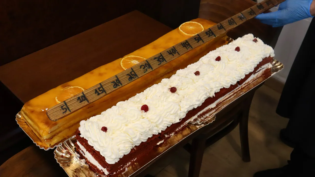 Bolo de um metro medido com fita métrica, coberto de chantilly