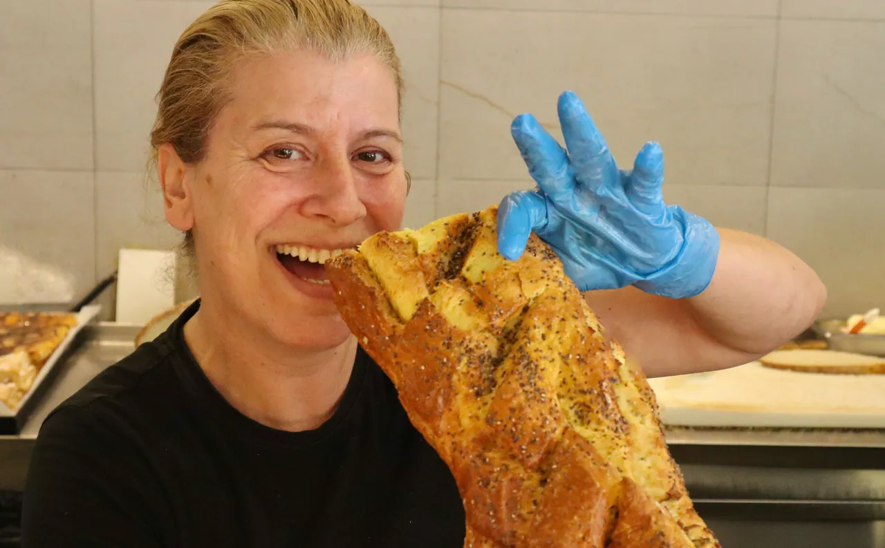 Funcionária a trincar uma tosta acabada de fazer