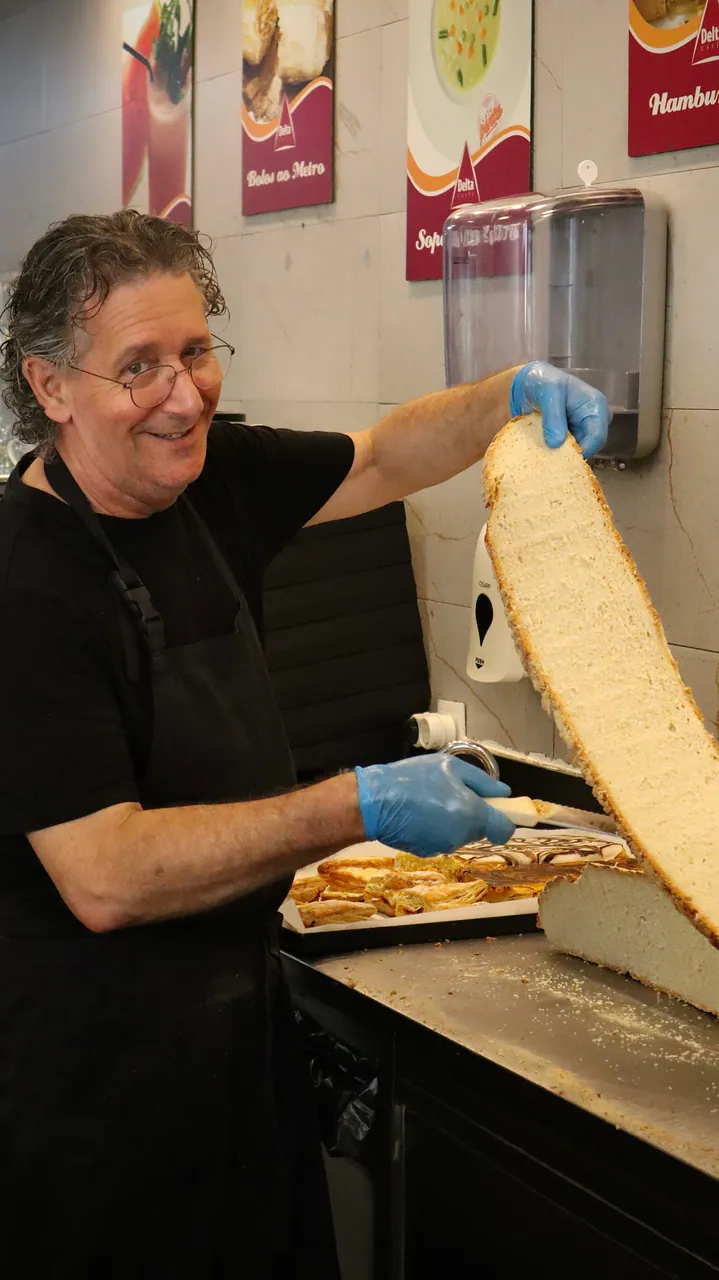 Funcionário a mostrar o pão artesanal de um metro aberto