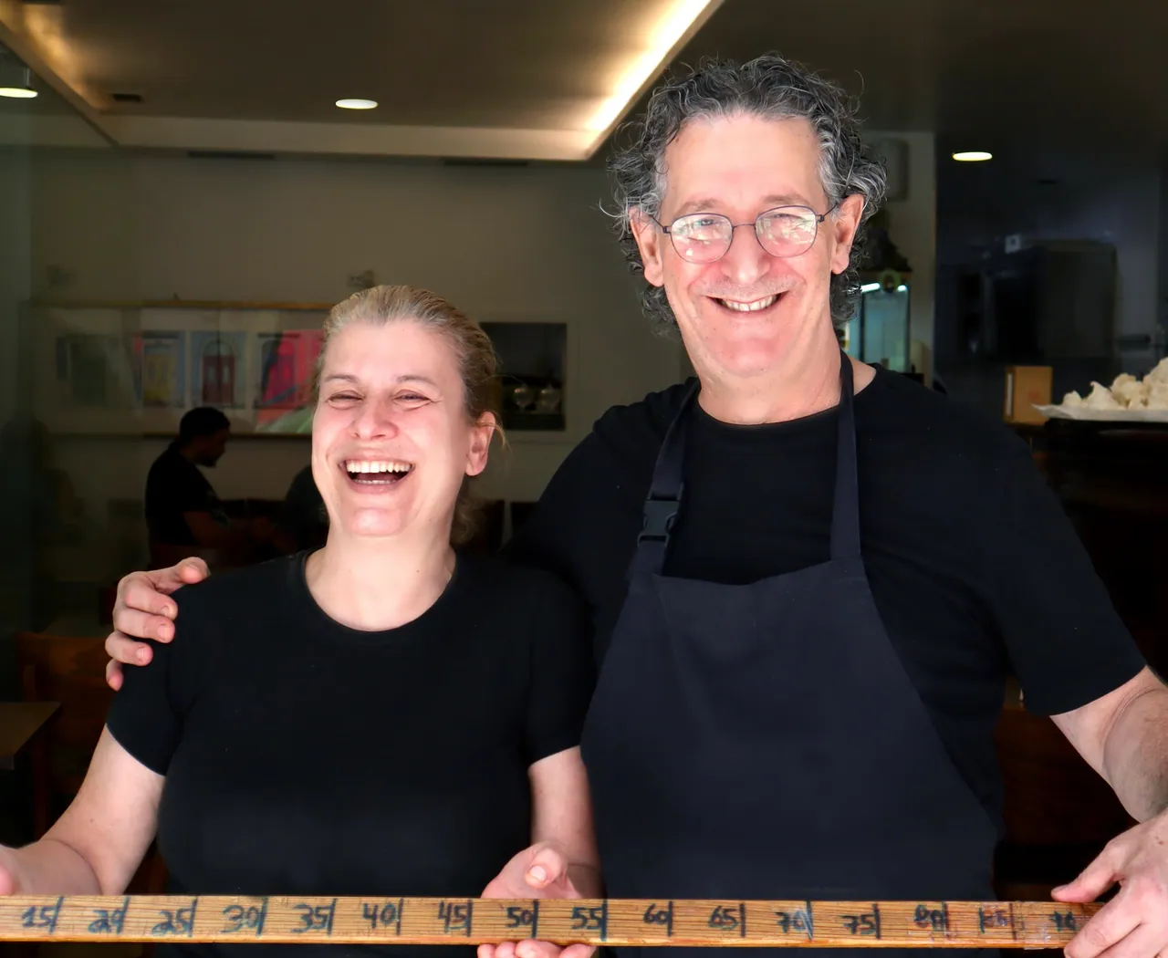 A equipa do Penta Café a sorrir, com a fita métrica das tostas