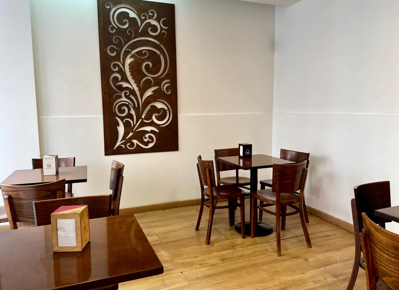 Sala do café com mesas e um painel decorativo