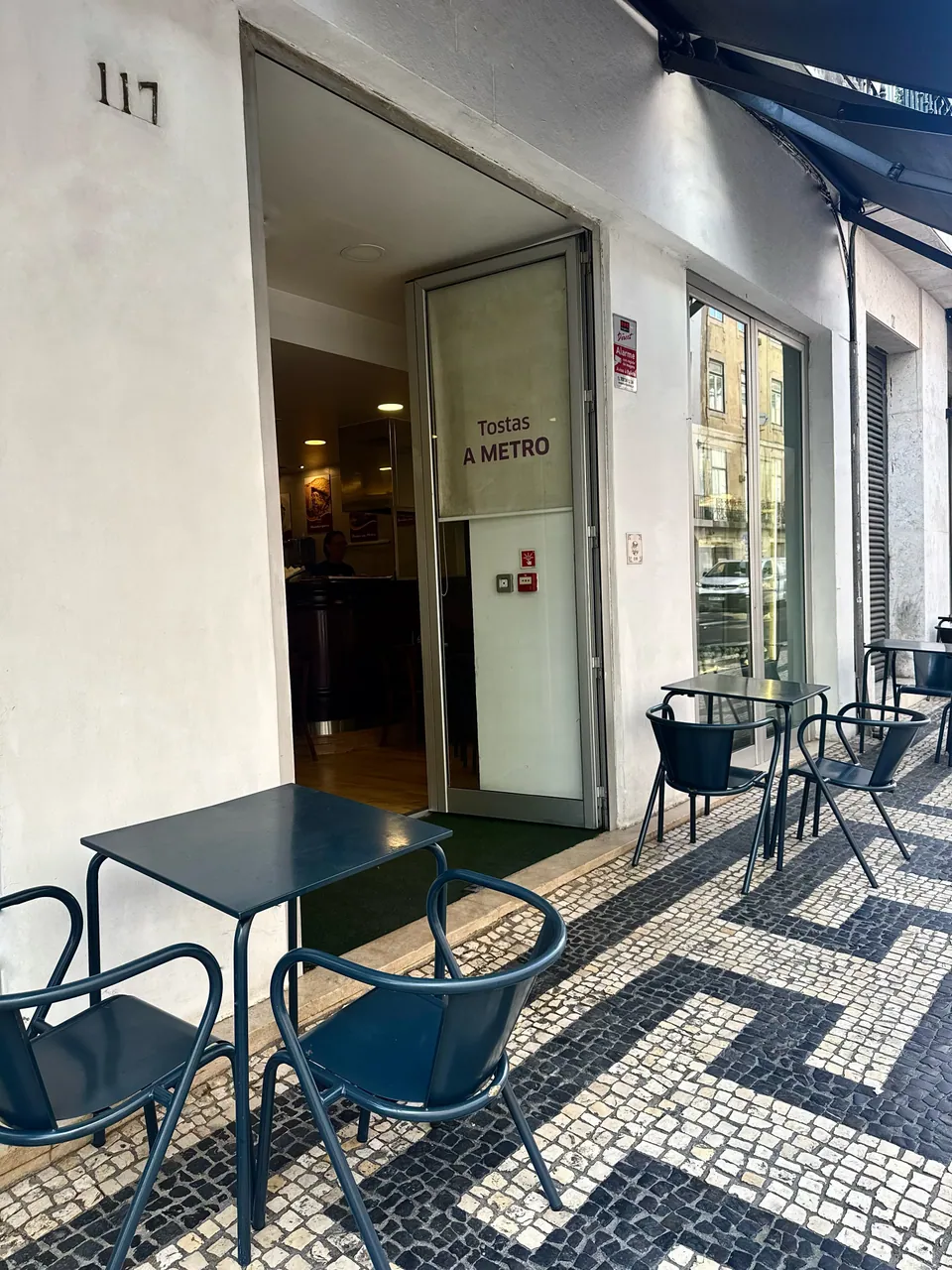 Entrada do Penta Café no nº 117, com esplanada na calçada