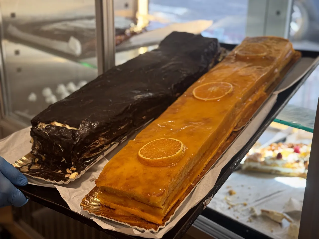 Bolo a metro de chocolate e laranja junto à vitrine