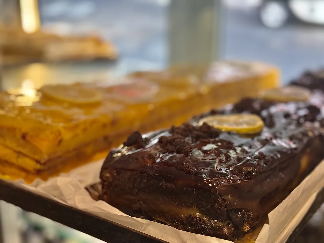 Bolos a metro junto à janela: laranja e chocolate