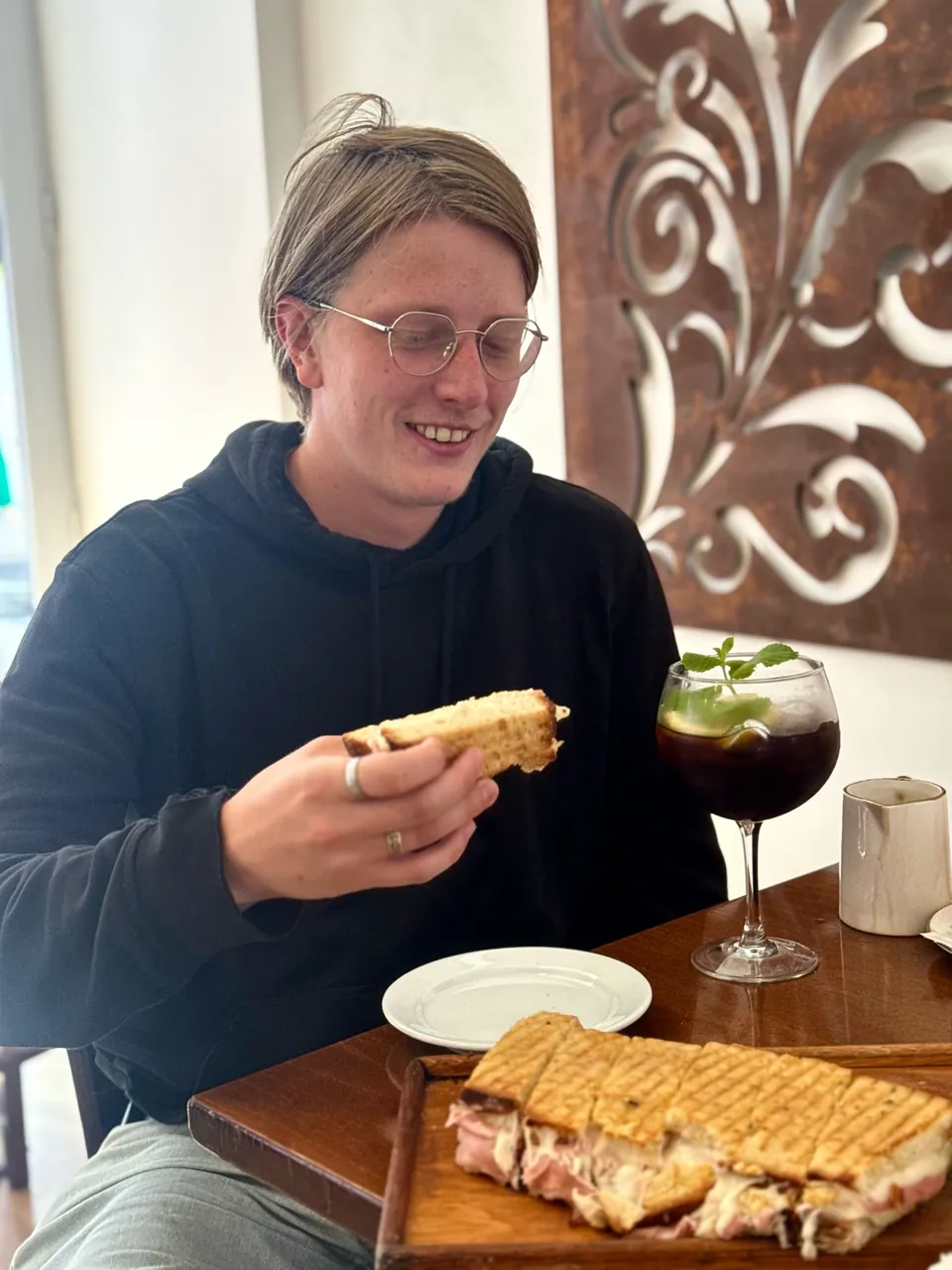 Cliente a comer uma tosta numa mesa do café